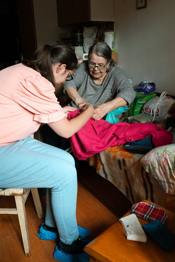 services-img A caregiver helps a senior woman with sewing indoors in Prague.