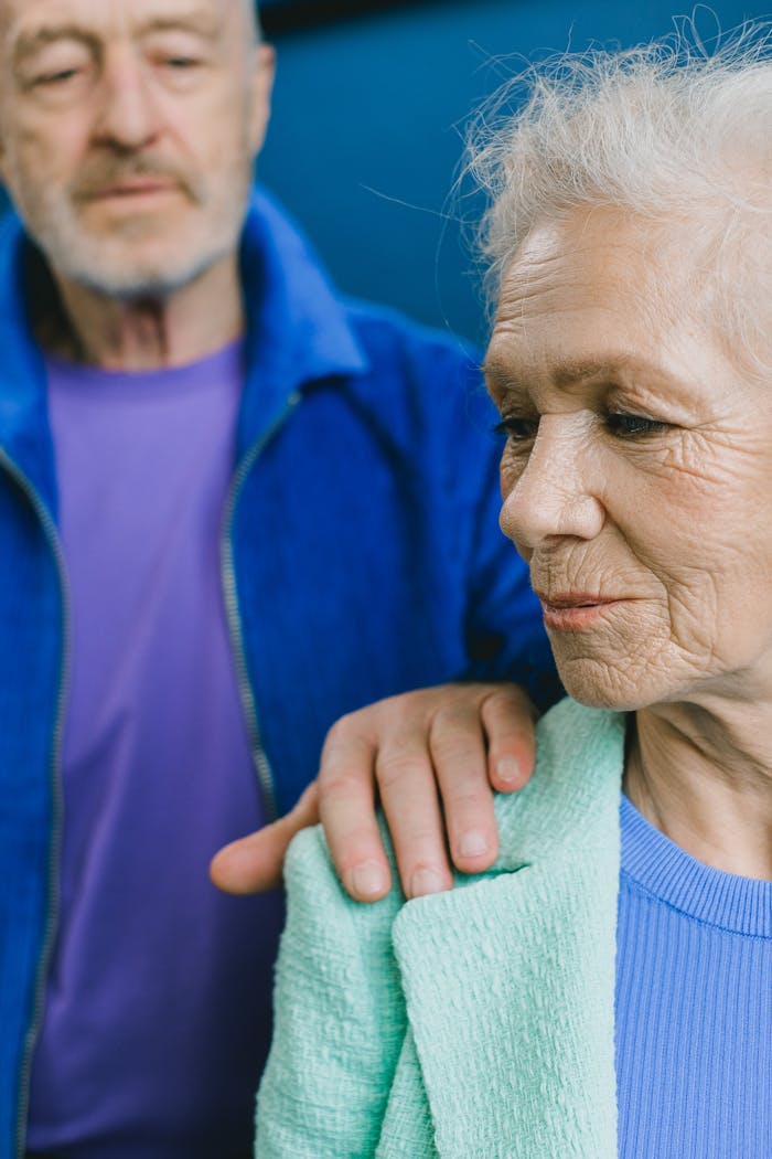 ours-journey An elderly couple sharing a tender moment indoors. Senior man comforting woman with a gentle touch.