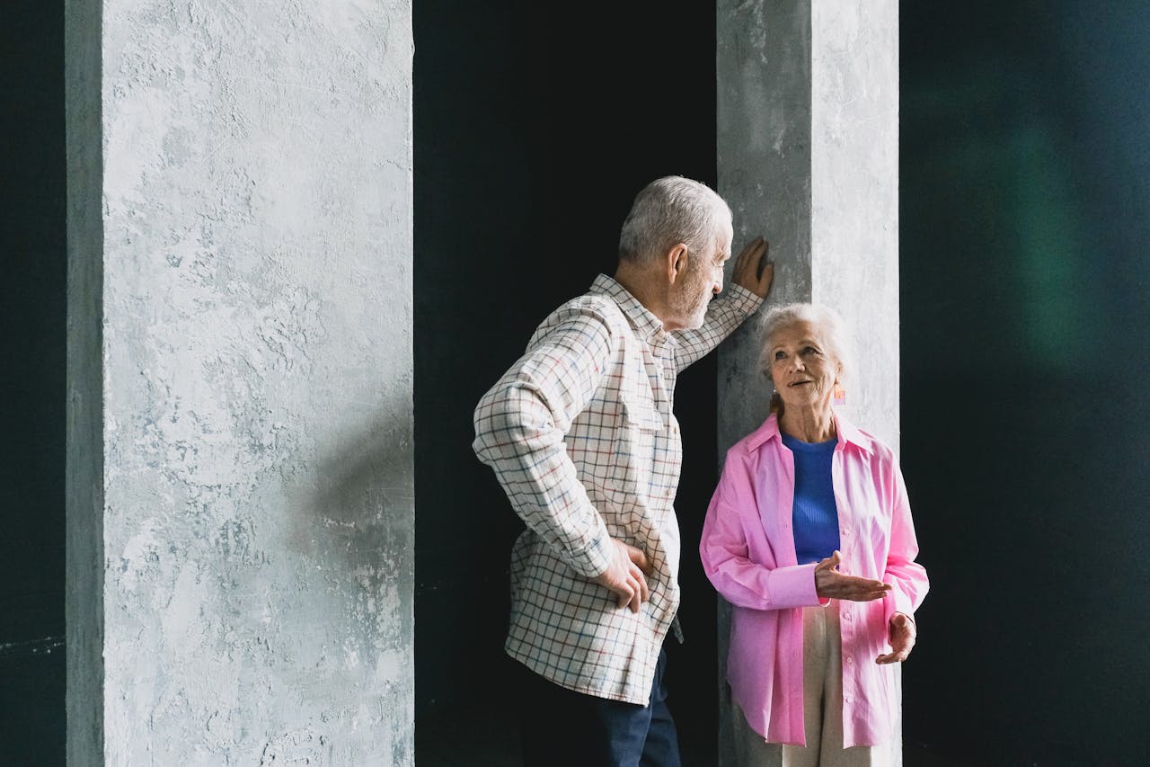 services-01 Elderly couple engaging in a warm conversation indoors, showcasing affection and happiness.